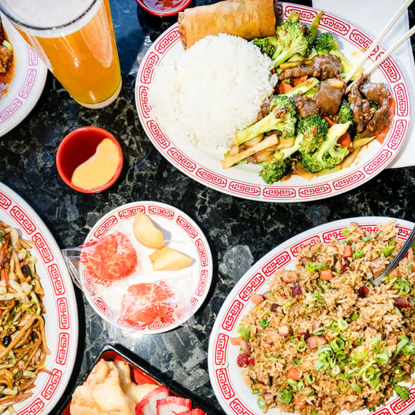 Overhead view of various Chinese dishes, including beef and broccoli, fried rice, and lo mein.