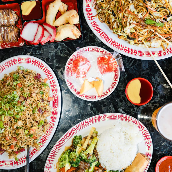 Overhead view of various Chinese dishes, including fried rice, lo mein, beef and broccoli, and appetizers.